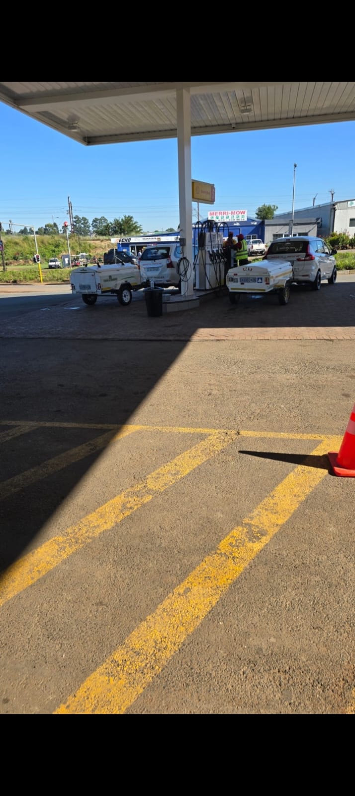 Two Southern Berg Shuttle vehicles with trailers refuelling before an airport run