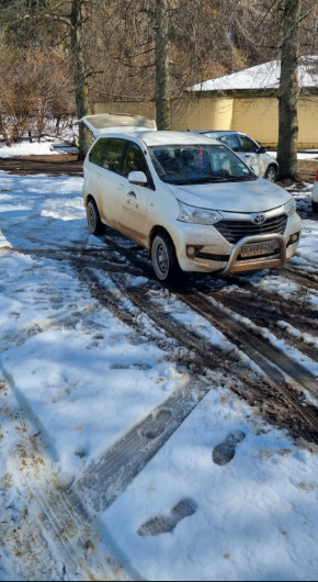 White Southern Berg Shuttle Avanza parked in melting snow at a mountain lodge