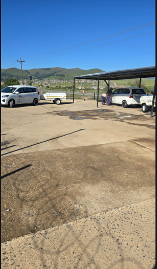 Southern Berg Shuttle vehicles and trailer at the yard with the Berg foothills behind