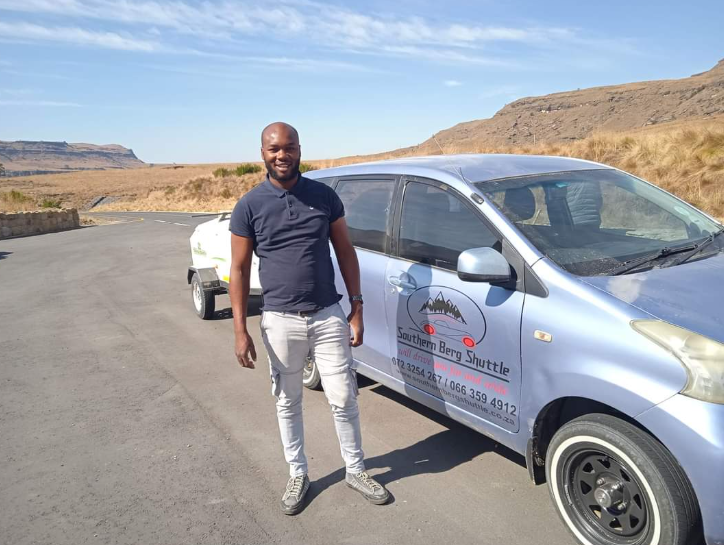 Owner-driver standing beside the Southern Berg Shuttle vehicle high in the Berg