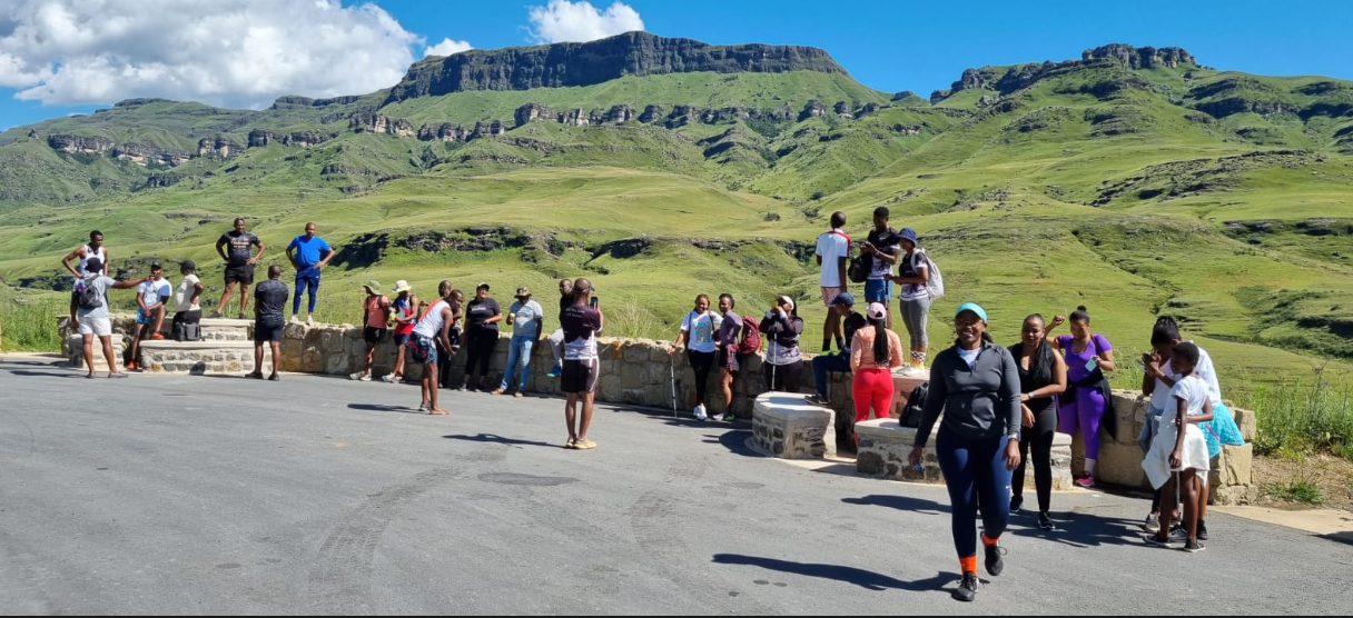 Passenger group at a green Drakensberg viewpoint on a clear summer day